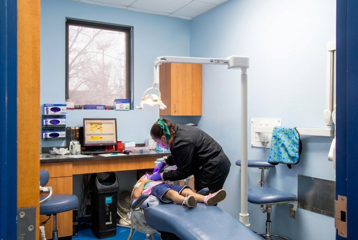 Dental assistant with young patient at Monroe office